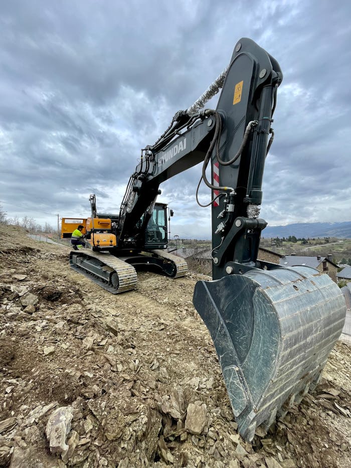 Excavator digging at a construction site under cloudy skies. Perfect for industrial and machinery themes.